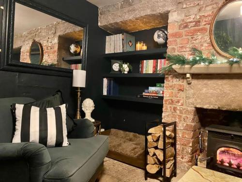 - un salon avec un canapé et une cheminée dans l'établissement The Old Hat Shop, à Cromford