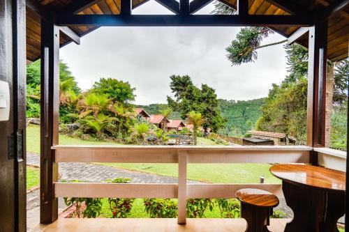 a view from the balcony of a resort with a table and chairs at Pousada das Pedras in Monte Verde
