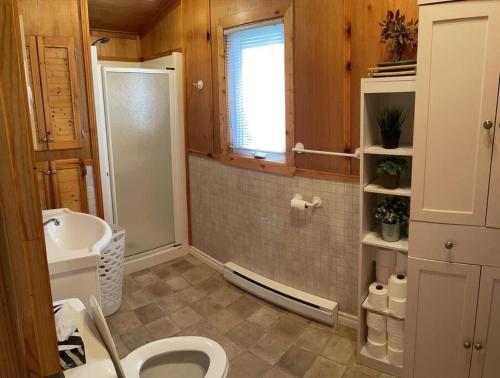 La salle de bains est pourvue de toilettes et d'un lavabo. dans l'établissement Chalet unique et chaleureux en pleine nature, à Shawinigan