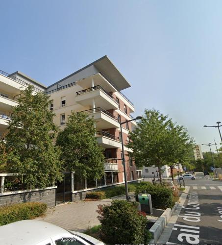 un bâtiment dans une rue de la ville avec un parking dans l'établissement Studio 23 m2 avec terrasse 16 m2 - Corporate housing ou bail civil travailleur mobilité Résidence standing Atlantis Plein Sud, à Massy