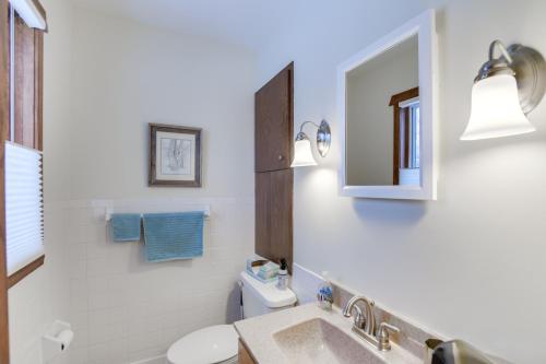ein Badezimmer mit einem Waschbecken, einem WC und einem Spiegel in der Unterkunft Pet-Friendly Moorhead Home with Private Hot Tub! in Moorhead