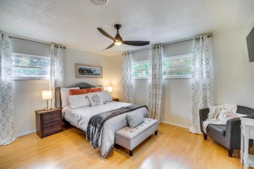 a bedroom with a bed and a chair and windows at Centrally Located Merritt Island Home Pool, Porch in Merritt Island