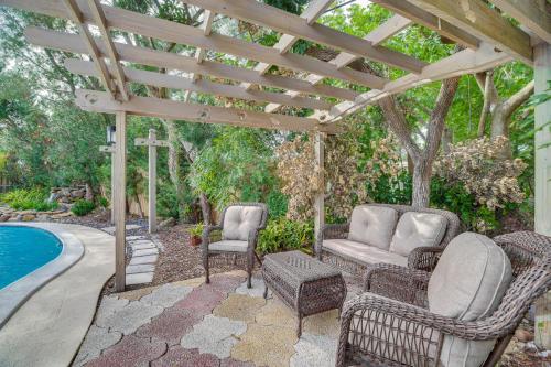 a patio with chairs and a pergola next to a pool at Centrally Located Merritt Island Home Pool, Porch in Merritt Island