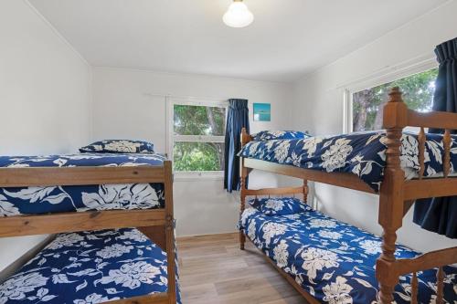 a bedroom with four bunk beds and a window at The Shack Rainbow Beach - Pets Welcome - Fully Fenced - Close to Beach in Rainbow Beach