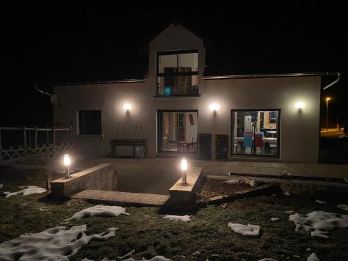 a house at night with two lights in the yard at Maison chaleureuse au cœur du massif Jurassien in Saint-Pierre