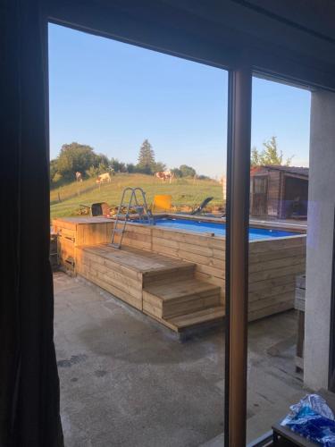 a view of a swimming pool from a window at Maison chaleureuse au cœur du massif Jurassien in Saint-Pierre
