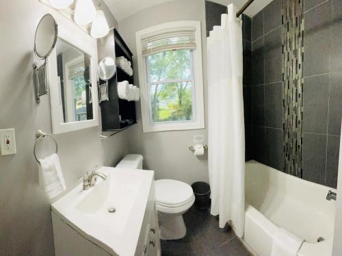 a bathroom with a sink and a toilet and a tub at Modern & Spacious-walk to metro w/ parking On-site in Silver Spring