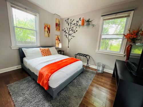 una camera con un letto e una coperta arancione di Modern & Spacious-walk to metro w/ parking On-site a Silver Spring