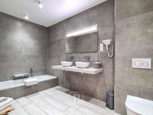 a bathroom with two sinks and a mirror at Villa Blue Garden B&B Vlaamse Ardennen nabij Pairi Daiza in Geraardsbergen