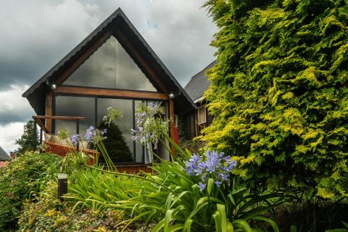 a house with a window and flowers in front of it at Pousada das Pedras in Monte Verde