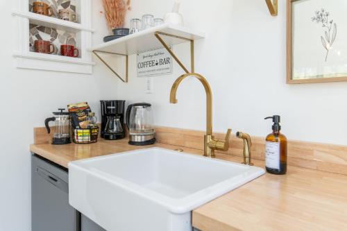 a kitchen counter with a white sink in a kitchen at Loft on Capital - Ideally located to Distilleries in Frankfort