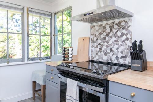a kitchen with a stove top oven next to windows at Loft on Capital - Ideally located to Distilleries in Frankfort