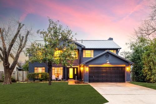 a blue house with a garage at Timeless-Texas-Inn - Heated Pool Oasis & Lux Vibe in Round Rock