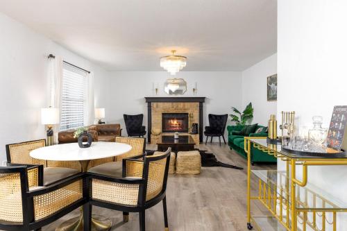 a living room with a table and chairs and a fireplace at Timeless-Texas-Inn - Heated Pool Oasis & Lux Vibe in Round Rock