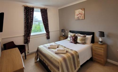 um quarto com uma cama com duas toalhas em The White Horse Lodge Hotel em Thirsk