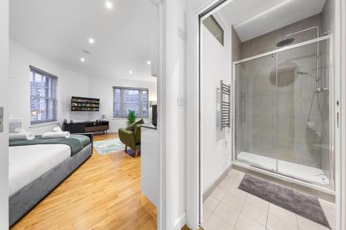 una camera con doccia e un letto in una stanza di Modern Studio Flat - Sleeps 3 - Near Heathrow, Windsor Castle, Thorpe Park - Staines London TW18 a Staines upon Thames