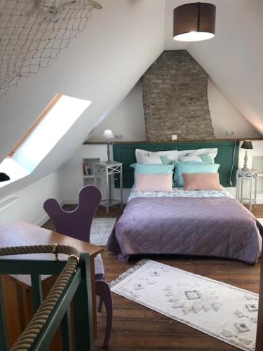 um quarto com uma cama e uma mesa num sótão em Les Hortensias em Amiens