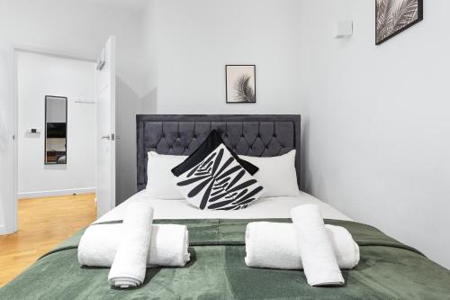 una camera da letto con un letto con cuscini bianchi e neri di Modern Studio Flat - Sleeps 3 - Near Heathrow, Windsor Castle, Thorpe Park - Staines London TW18 a Staines upon Thames