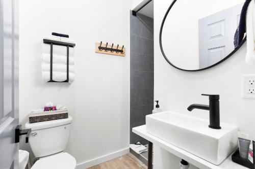 a white bathroom with a sink and a mirror at South Bay Inn in Westport