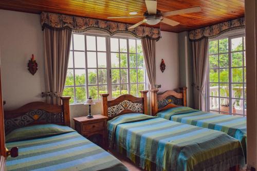 2 Betten in einem Zimmer mit Fenstern in der Unterkunft Tebaida villa puebla in La Tebaida