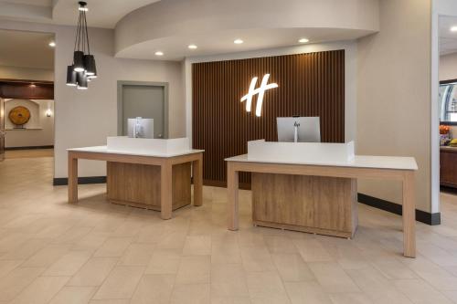 a lobby with two tables in a building at Holiday Inn El Paso West – Sunland Park by IHG in El Paso