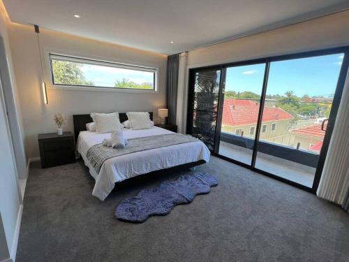 a bedroom with a large bed and a large window at Stylish Serenity at Sunrise in Fairy Meadow
