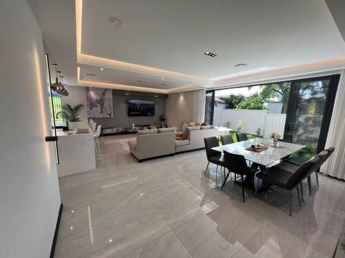 a dining room and living room with a table and chairs at Stylish Serenity at Sunrise in Fairy Meadow