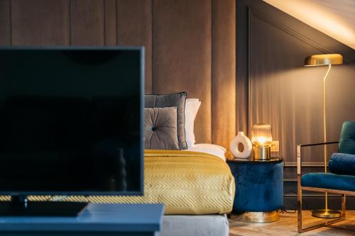 a hotel room with a bed and a television at Central Palace - LoftAffair Collection in Kraków