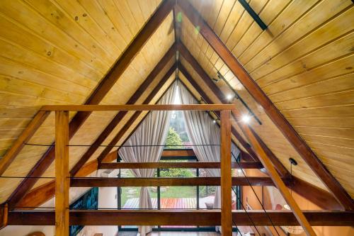 a wooden staircase in a cabin with a large window at Pousada das Pedras in Monte Verde