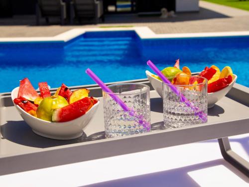 a tray with bowls of fruit and glasses of water at Fantasy Daydream Mansion in Novalja