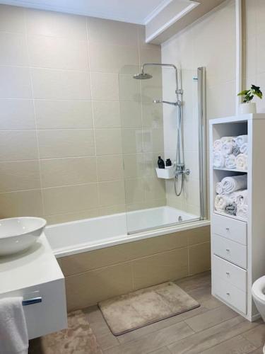 a bathroom with a shower and a tub and a sink at Welcome Pico in Madalena