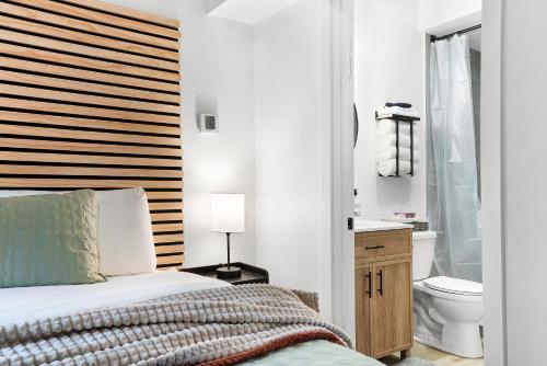 西港的住宿－South Bay Inn，一间卧室设有一张床、一个卫生间和一个水槽