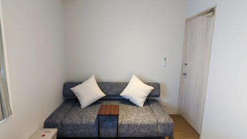 a couch with two pillows on it in a room at MAHHO TERRACE MIYAKO in Miyako Island