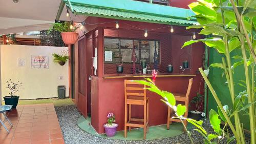 a small bar in a building with two chairs at Hostal Nuevo Arenal downtown, private rooms with bathroom in Nuevo Arenal