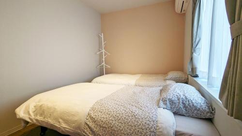 a small bedroom with a bed and a window at MAHHO TERRACE MIYAKO in Miyako Island