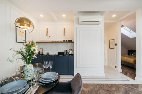 a kitchen and dining room with a table and chairs at Central Palace - LoftAffair Collection in Kraków