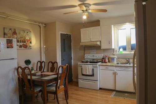 a kitchen with a table and a kitchen with white appliances at Cozy stay close to Merivale in Ottawa