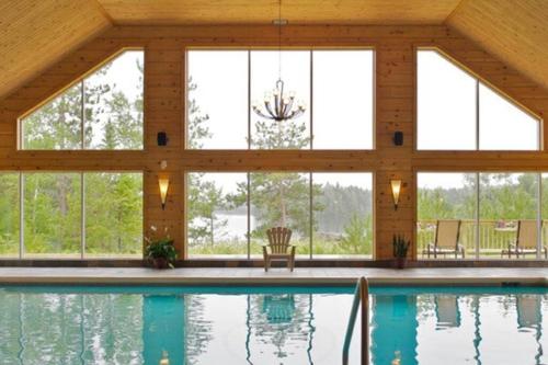 a room with a pool and windows at Rustic & Modern Chalet 32 Acre of Land in Saint-Paulin