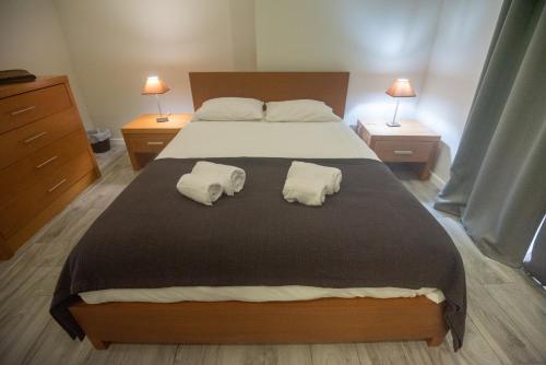 ein Schlafzimmer mit einem großen Bett und zwei Handtüchern in der Unterkunft Vista do Baixio in Vila Franca do Campo