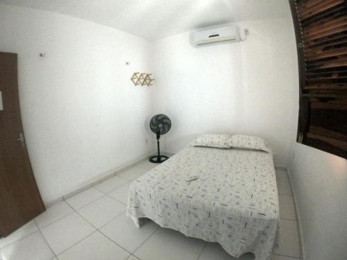 um quarto branco com uma cama e uma ventoinha em CASA PORTO em Luís Correia