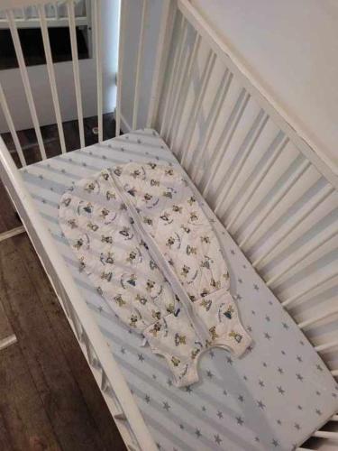 a white crib with a blanket on it at Le Nid Cabailla in Coimères