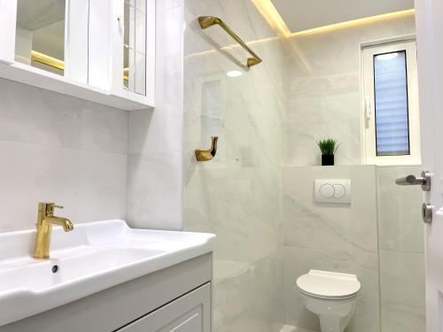 een witte badkamer met een wastafel en een toilet bij Central single house with parking-TOP LOCATION! in Novalja