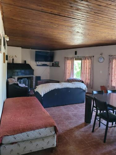 a bedroom with a bed and a table and a dining room at Departamento Castello in El Bolsón