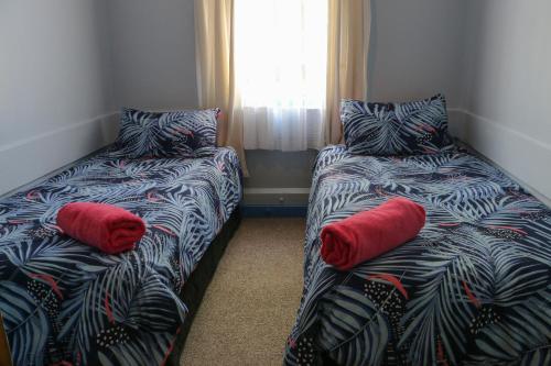 Cette chambre comprend 2 lits avec des oreillers rouges. dans l'établissement Formerly the Blackball Hilton, à Blackball