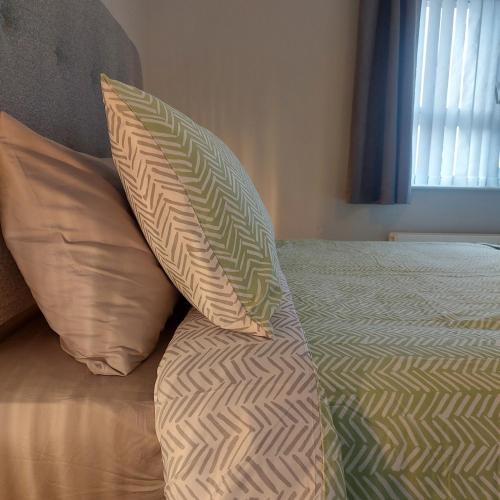 a bed with two pillows on top of it at Lawnbrook Town House in Belfast