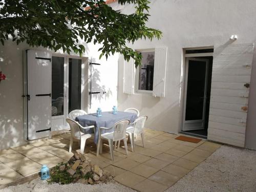 - une table bleue et des chaises blanches sur la terrasse dans l'établissement Villa au Calme avec Extérieur et parking gratuit aux portes d'Aix et Marseille Emplacement idéal, à Marseille