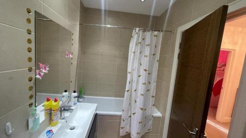 a bathroom with a shower curtain and a sink at Modern and Unique Home in London, Chiswick in London