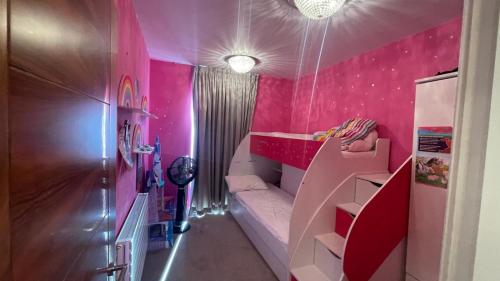 een kleine kamer met roze muren en een stapelbed bij Modern and Unique Home in London, Chiswick in Londen