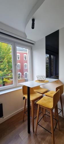 a dining room with a table and chairs and windows at LUX Centro Storico in Sarajevo
