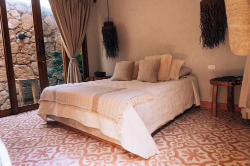 a bedroom with a bed in a room with a window at Las Dunas Beach Guest House in Juan de Acosta